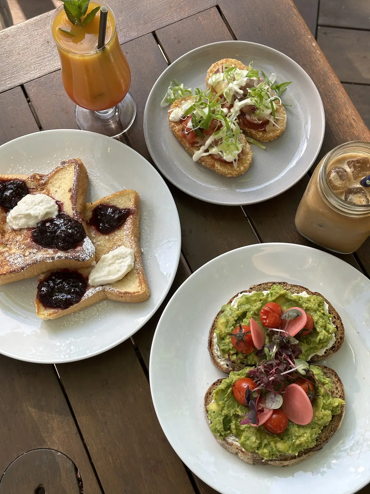 French toast, smashed avocado and an iced coffee on a timber table