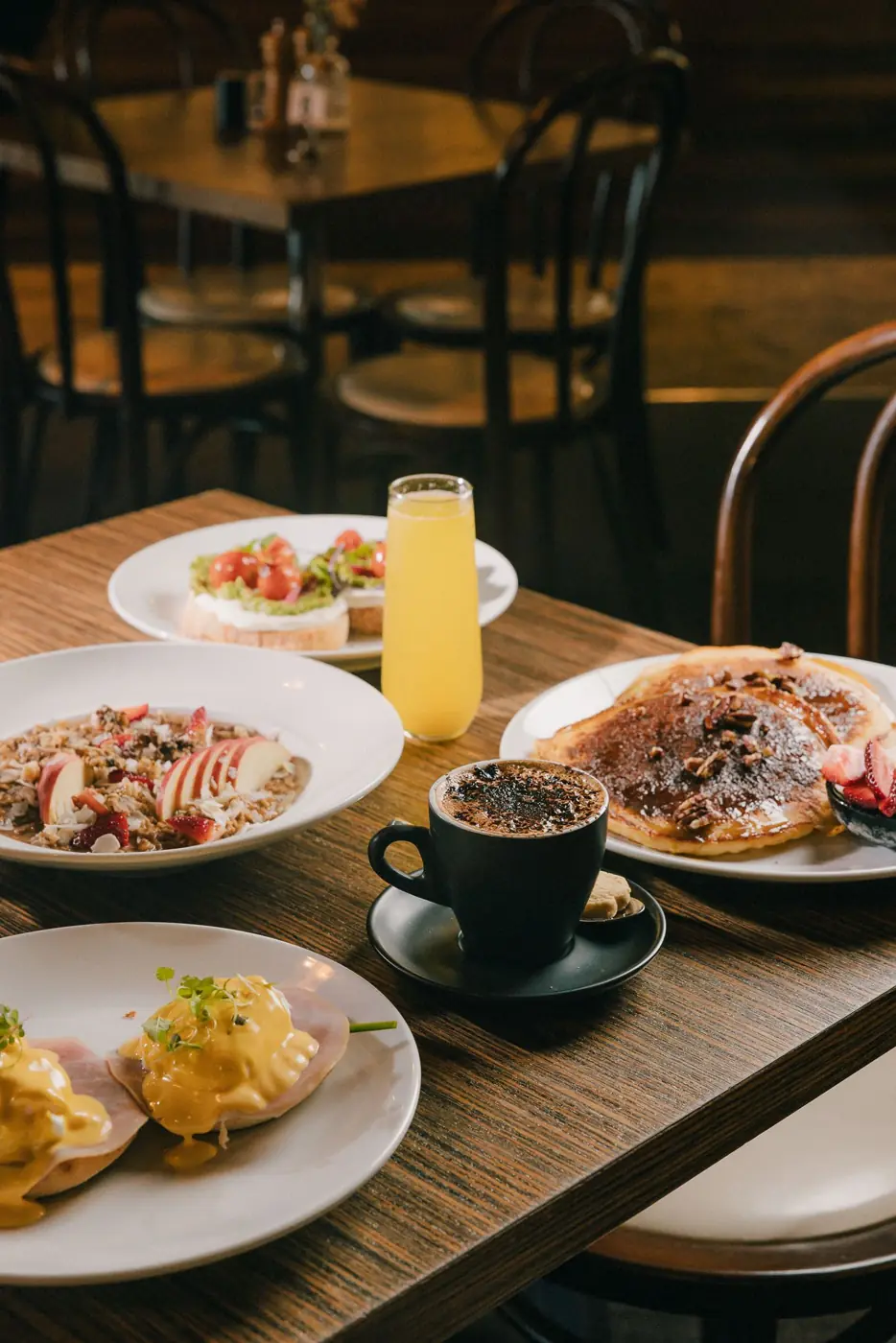 Pancakes, coffee and brunch plates on a table in the dining room