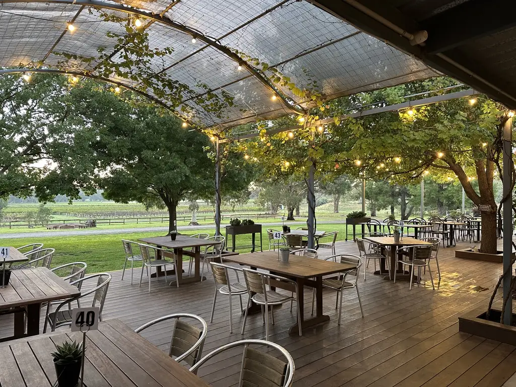 The outdoor deck under festoon lights, looking out to the vineyard