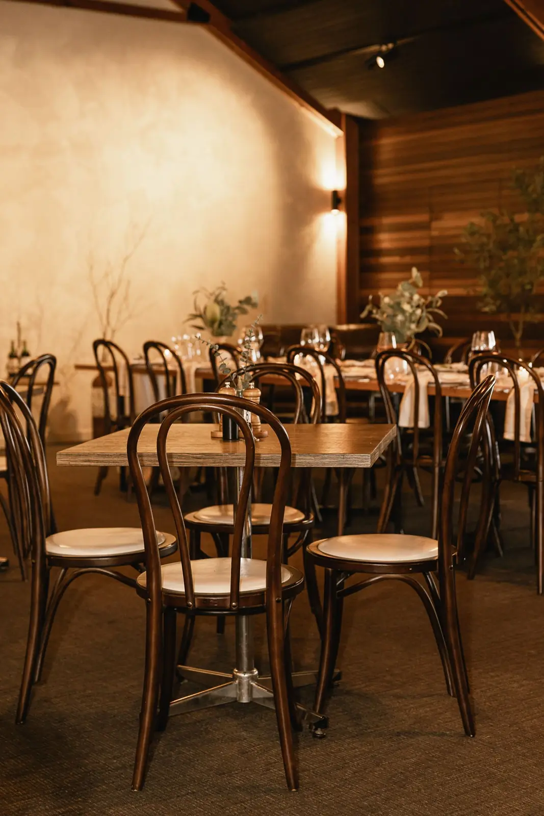 The dining room with bentwood chairs and set tables