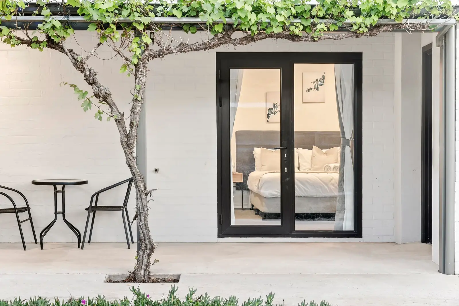 A queen suite seen from the courtyard through its glass doors