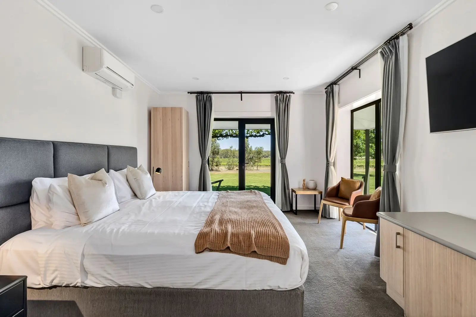 A king suite with the bed facing glass doors to the grounds