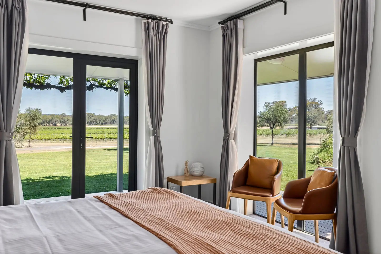 A suite with armchairs by windows looking out to the vineyard