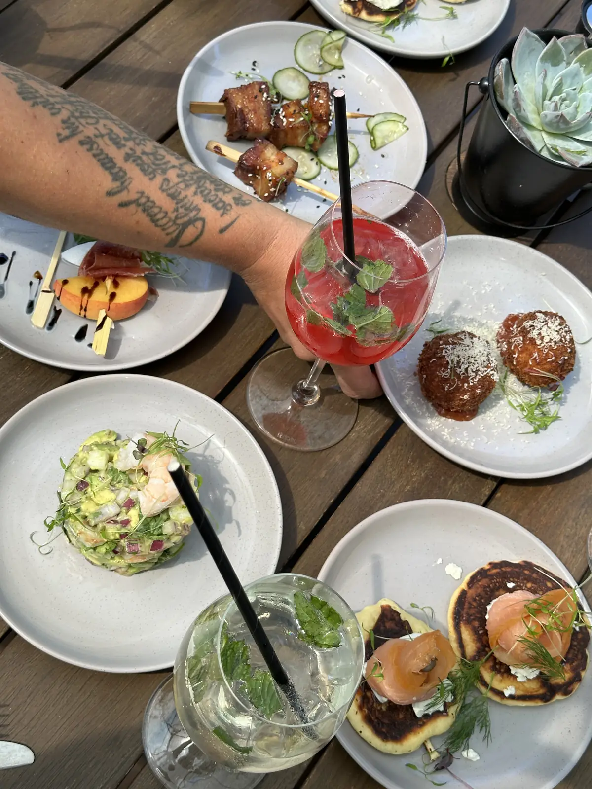 Small plates and a cocktail shared across a table